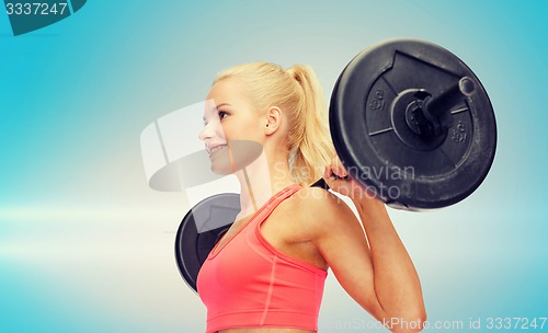 Image of smiling sporty woman exercising with barbell