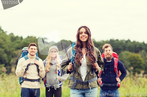 Image of group of smiling friends with backpacks hiking