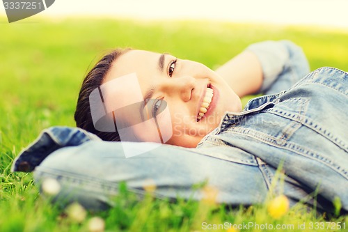 Image of smiling young girl lying on grass