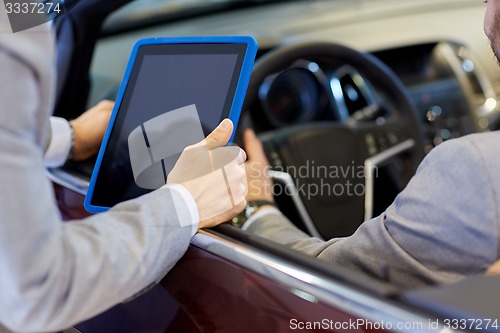 Image of close up of men with tablet pc in car salon