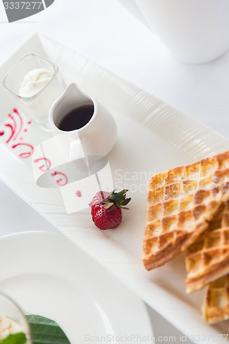 Image of close up of waffles on plate at breakfast table