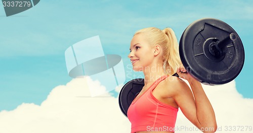 Image of smiling sporty woman exercising with barbell