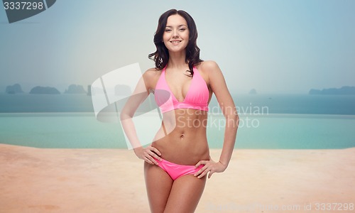 Image of happy woman in bikini over swimming pool