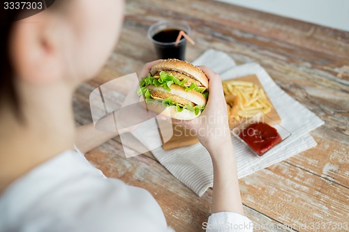Image of close up of woman hands holding hamburger