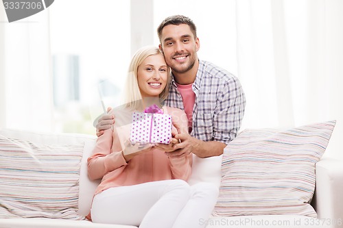 Image of happy man giving woman gift box at home