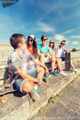 Image of group of smiling friends sitting on city street