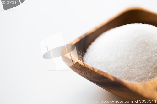 Image of close up of white sugar heap in wooden bowl