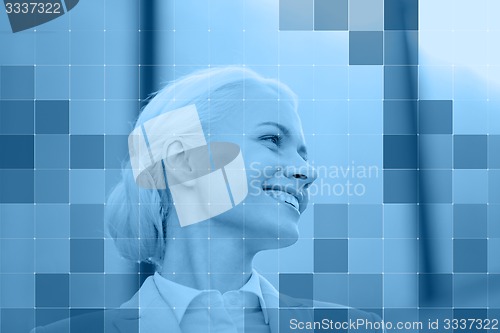 Image of smiling businesswoman behind monochrome blue grid
