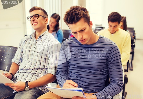 Image of group of smiling students in lecture hall