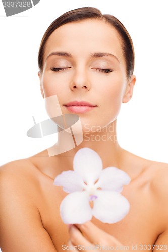 Image of relaxed woman with orhid flower