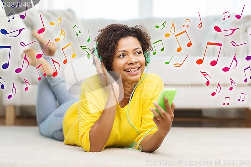 Image of happy african woman with smartphone and headphones