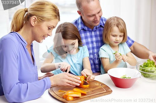 Image of happy family with two kids cooking at home