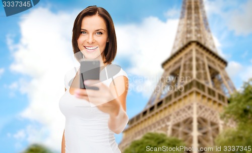 Image of woman taking selfie with smartphone in paris