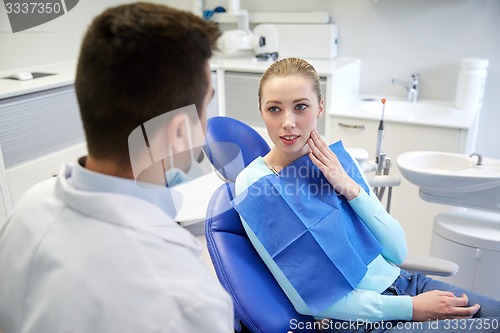 Image of male dentist with woman patient at clinic