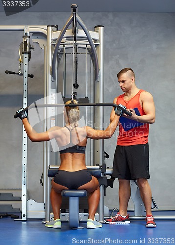 Image of man and woman flexing muscles on gym machine