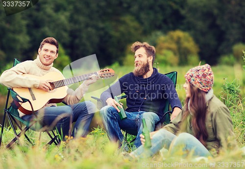 Image of group of tourists playing guitar in camping