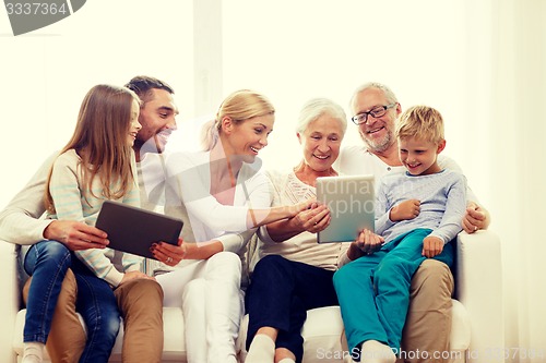 Image of smiling family with tablet pc at home