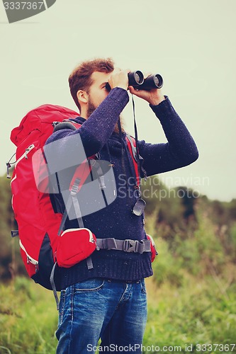 Image of man with backpack and binocular outdoors