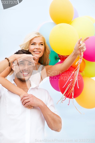 Image of couple with colorful balloons at seaside