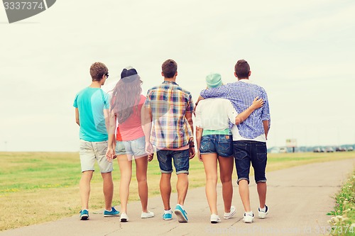 Image of group of teenagers walking outdoors from back
