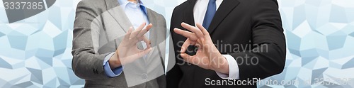 Image of businessman and businesswoman showing ok sign