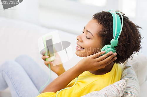 Image of happy african woman with smartphone and headphones