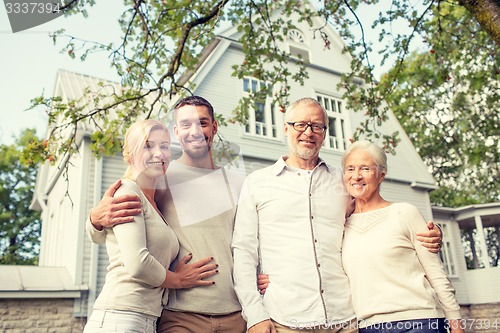 Image of happy family in front of house outdoors