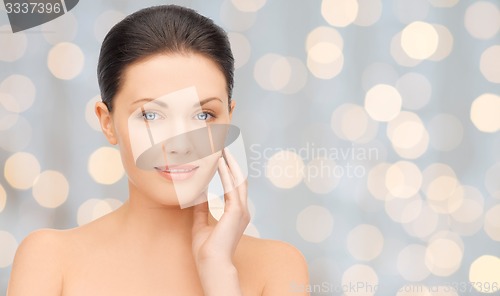 Image of beautiful young woman touching her face