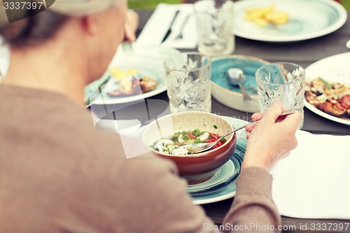 Image of close up of woman eating soup in summer garden