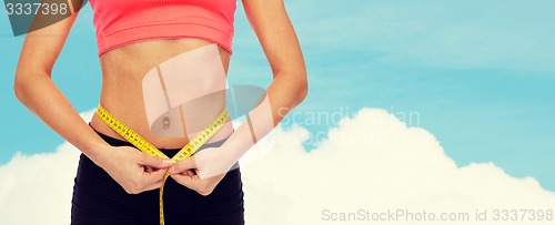 Image of close up of female hands measuring waist