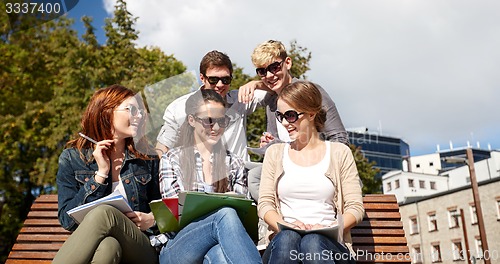 Image of group of happy students with notebooks at campus