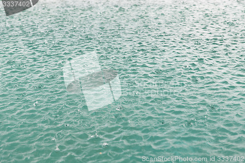 Image of water surface with raindrops at rainy day