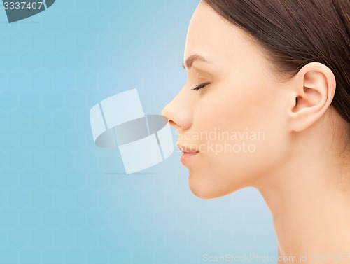 Image of beautiful young woman face over blue background
