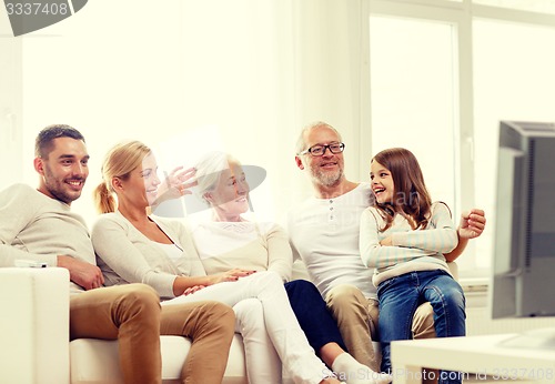 Image of happy family watching tv at home