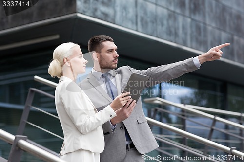 Image of serious businessmen with tablet pc outdoors