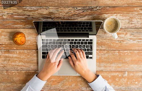 Image of close up of female hands with laptop and coffee