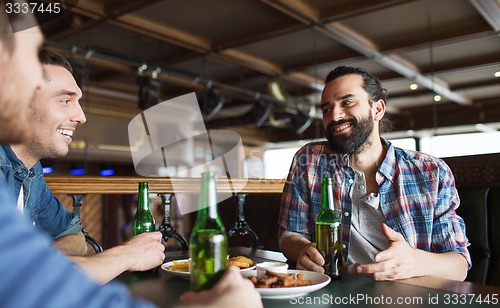 Image of happy male friends drinking beer at bar or pub