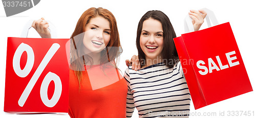 Image of two smiling teenage girl with shopping bags