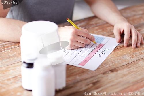 Image of close up of man with protein jars and diet plan