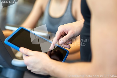 Image of close up of trainer hands with tablet pc in gym