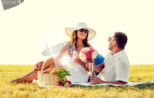 Image of smiling couple drinking champagne on picnic