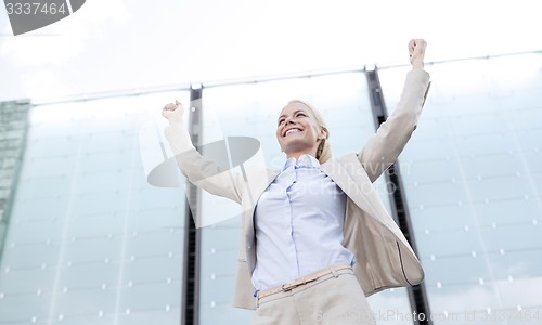 Image of young smiling businesswoman over office building