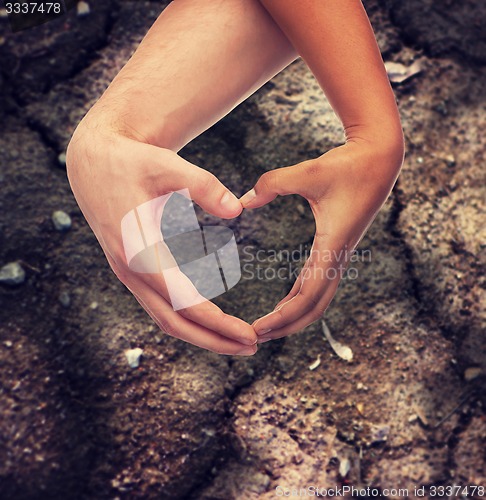 Image of woman and man hands showing heart shape