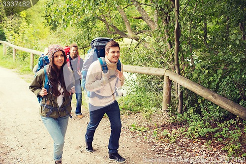 Image of group of smiling friends with backpacks hiking