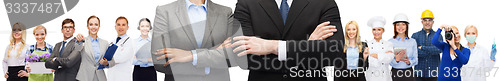 Image of businesswoman and businessman with crossed arms