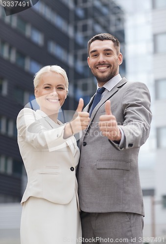 Image of smiling businessmen showing thumbs up