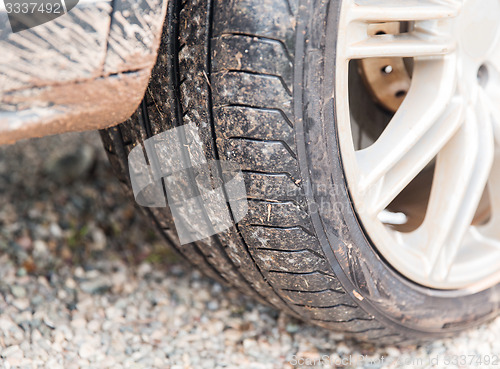 Image of close up of dirty car wheel on ground