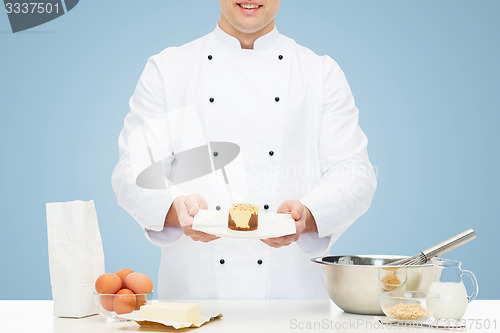 Image of close up of happy male chef cook baking dessert