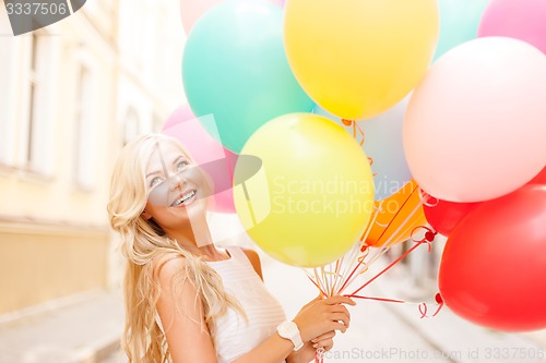 Image of smiling woman with colorful balloons