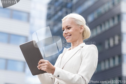 Image of smiling businesswoman with tablet pc outdoors